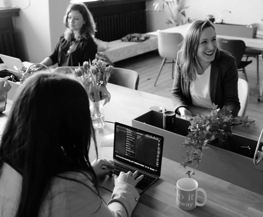 three women sitting at an office table