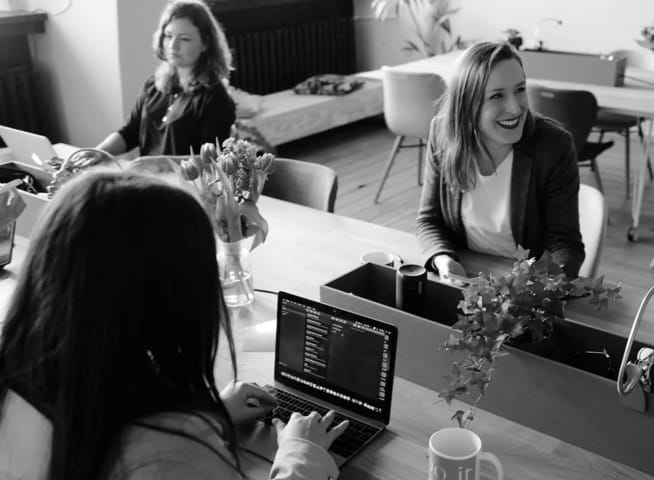 three women sitting at an office table